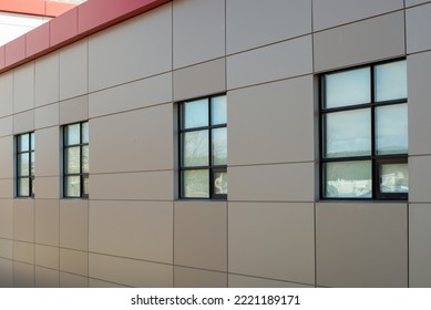 The exterior wall of a contemporary commercial style building with aluminum metal composite panels and glass windows. The futuristic building has engineered diagonal cladding steel frame panels. - Shutterstock ID 2221189171