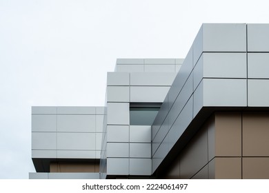 The exterior wall of a contemporary commercial style building with aluminum metal composite panels and glass windows. The futuristic building has engineered diagonal cladding steel frame panels.  - Shutterstock ID 2224061497