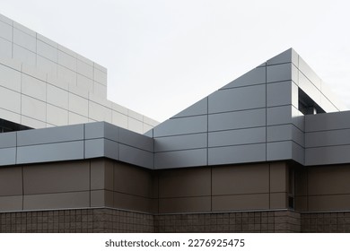 The exterior wall of a contemporary commercial style building with aluminum metal composite panels and glass windows. The futuristic building has engineered diagonal cladding steel frame panels.  - Shutterstock ID 2276925475