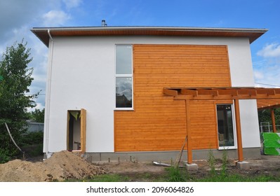 Exterior Walls Of A New House With A Patio: The Combination Of Wood Cladding, Siding, Paneling And White Stucco Or Plastering. 