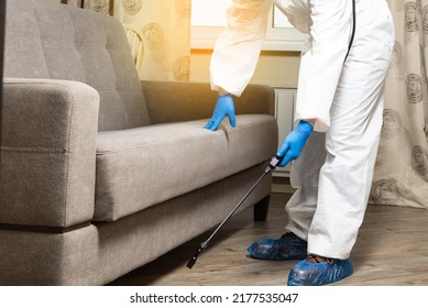 An Exterminator In Work Clothes Sprays Pesticides From A Spray Bottle. Fight Against Insects In Apartments And Houses. Disinsection Of Premises.