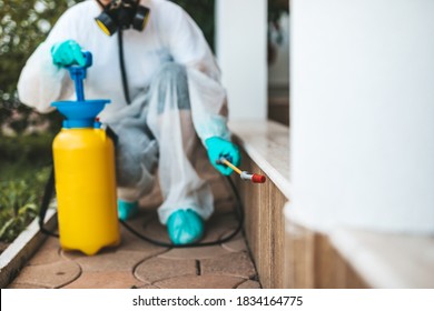 Exterminator In Work Wear Outdoors Spraying Pesticide With Sprayer