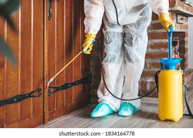 Exterminator In Work Wear Outdoors Spraying Pesticide With Sprayer