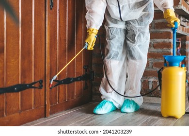 Exterminator In Work Wear Outdoors Spraying Pesticide With Sprayer.