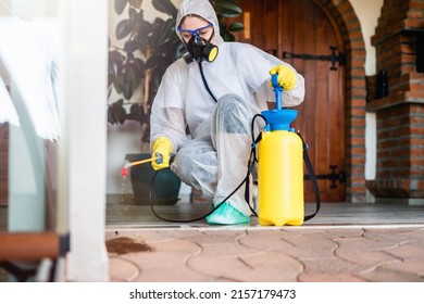 Exterminator In Work Wear Outdoors Spraying Pesticide With Sprayer