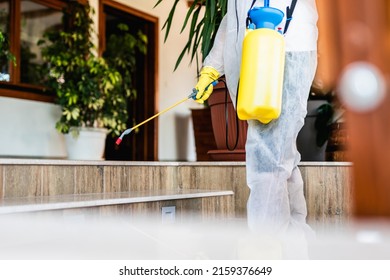 Exterminator In Work Wear Outdoors Spraying Pesticide With Sprayer