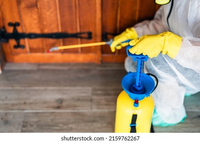 Exterminator In Work Wear Outdoors Spraying Pesticide With Sprayer