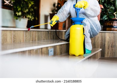 Exterminator In Work Wear Outdoors Spraying Pesticide With Sprayer