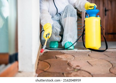 Exterminator In Work Wear Outdoors Spraying Pesticide With Sprayer