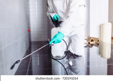 Exterminator In Workwear Spraying Pesticide With Sprayer