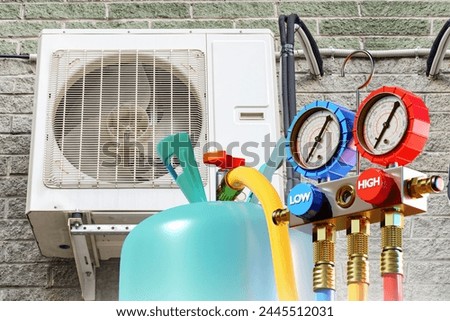 External air conditioner unit. Ozone cylinder. Refilling HVAC system. Refrigerant for air conditioning systems. Equipment for climate control. Air conditioner unit hangs on wall. HVAC technology