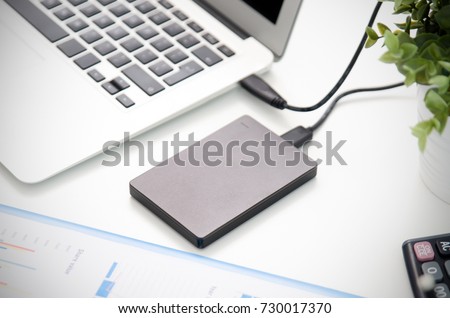 External backup disk hard drive connected to laptop. hard drive backup disk external computer data usb concept