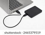 External backup hard disk drive connected to laptop on white background. external hard disk connect by USB 3.0 port to laptop