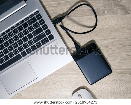 External backup hard disk drive connected to laptop on white background. external hard disk connect by USB 3.0 port to laptop