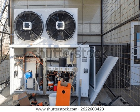 External conditioner unit on electrical cabinet. Ventilation communications building. Nitrogen tanks under conditioner. Supply ventilation pump on wall building. HVAC equipment. Split system repair
