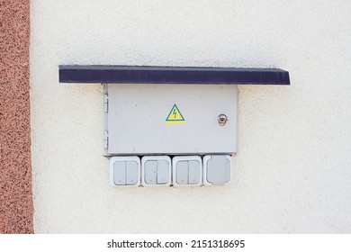 External Electrical Box With Lock Is Placed On Wall Of House From The Outside, Protected From Above By Metal Visor. Beware Of Electricity!