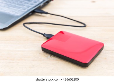 External Hard Drive For Backup On Wood Background.