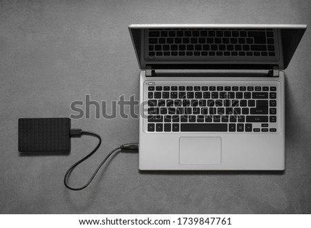 External Hard drive connected to the Laptop Computer. isolated on green background. top view. Portable hard drive with usb wire. Hard drive close up.