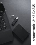 External hard drive, flash drive and SD card with laptop on black background