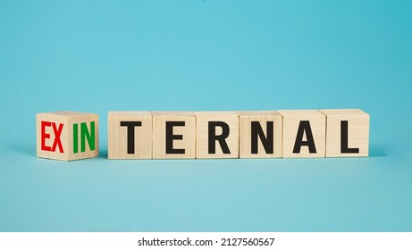 External and internal on wooden cubes, dice or blocks showing the words external and internal on blue background.Business concept.
