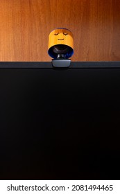 External Round Black Web Camera With A Smiling Cap On A Black Monitor. Smiling Cover For A Webcam. Protection Against Spying.