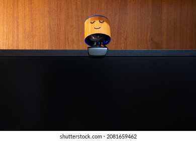 External Round Black Web Camera With A Smiling Cap On A Black Monitor. Smiling Cover For A Webcam. Protection Against Spying.