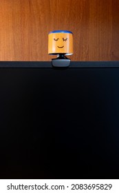 External Round Black Web Camera With A Smiling Cap On A Black Monitor. Smiling Cover For A Webcam. Protection Against Spying.