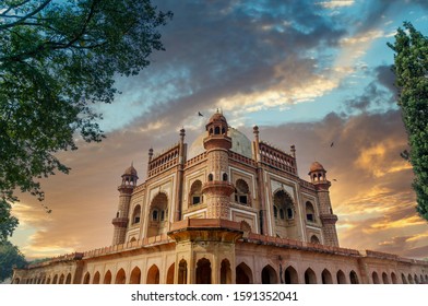 External side 45 degree view of Safdarjung tomb with blue sky and trees in the foreground. This historical monument is a popular tourist place