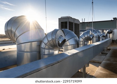 External unit of commercial air conditioning and ventilation system installed on industrial building roof. Exhaust vent on flat factory rooftop