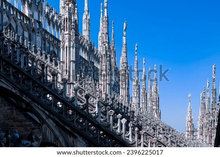 External view of Milan Cathedral (Duomo di Milano) from the rooftop, Milan, Lombardy, Italy, Europe. Historical marble facade with spires. Gothic architecture features. City travel tourism