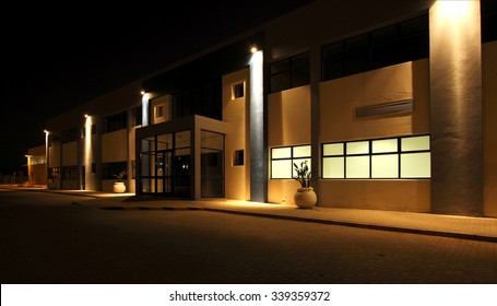 external view of a modern building at night with security floodlights burning