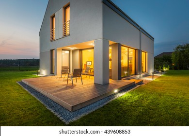 External View Of A New House At Night With Patio And Outdoor Lighting