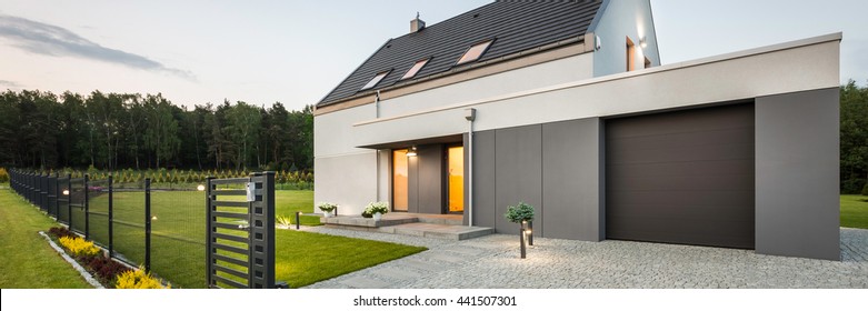 External View Of Stylish Family House With Fence, Garage, Stone Driveway And Garden, Panorama