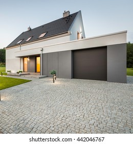 External View Of Stylish House With Big Garage And Stone Driveway