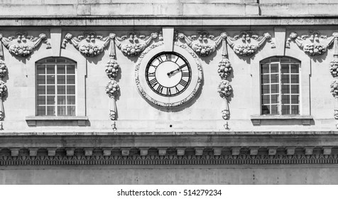 External Wall Clock Between Decorated Windows black and white photography