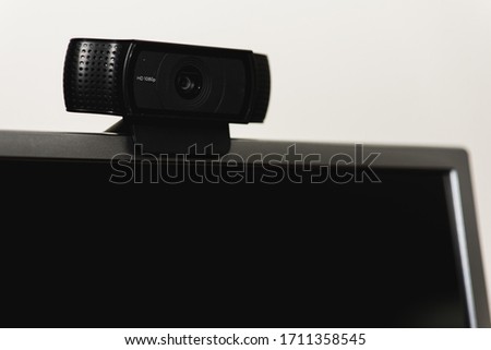 external webcam black for PC is placed on the monitor 