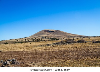 An Extinct Cinder Cone In The Distance Under Clear Blue Skies.