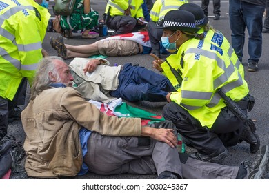 Extinction Rebellion protest down Whitehall in protest against HMRC and Barclays. Protestors sitting on the road being talked to by the police. London - 24th August 2021