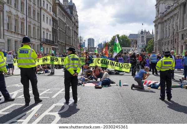 Extinction Rebellion\
protest down Whitehall in protest against HMRC and Barclays.\
Protestors with arms locked in tubes surrounded by the police.\
London - 24th August\
2021