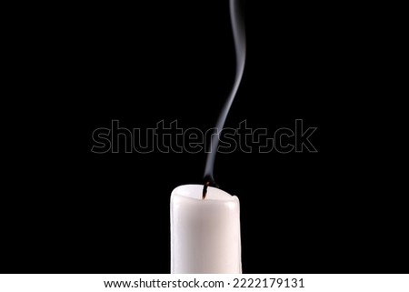 Extinguished candle with smoke isolated on black background
