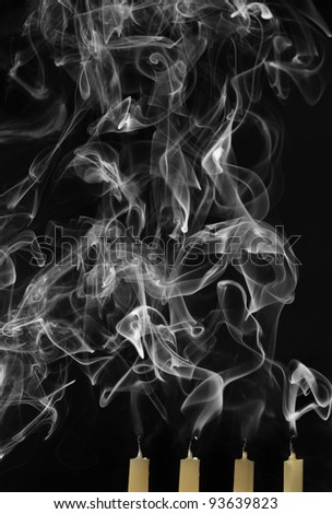 Extinguished candles with smoke on black background