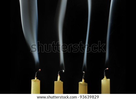 Extinguished candles with smoke on black background