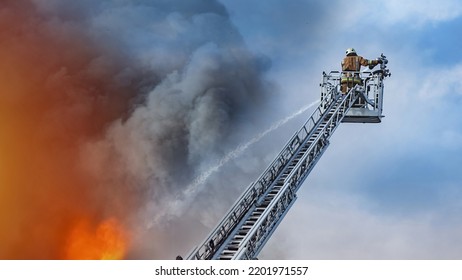 Extinguishing fire. Fireman on retractable ladder. Putting out fires from above. Firefighter pours water on fire. Guy puts out flame from retractable ladder. Firefighter officer at work
