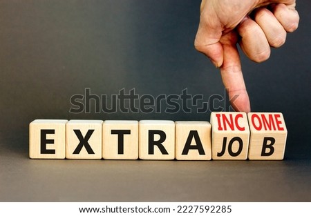 Extra job and income symbol. Concept words Extra job Extra income on wooden cubes. Businessman hand. Beautiful grey table grey background. Business extra job and income concept. Copy space.