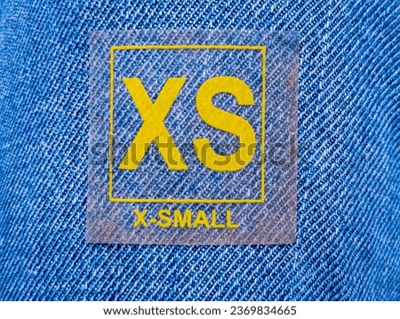 Extra small size sticker attached on denim jean texture 
