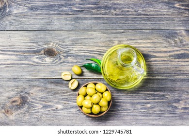 Extra vergin olive oil in glass jar, marinated olives in wooden bowl on rustic background. Top view, space for text. - Powered by Shutterstock