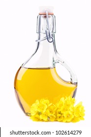 Extra Virgin  Oil In A Bottle With Rapeseed Flowers Isolated On White