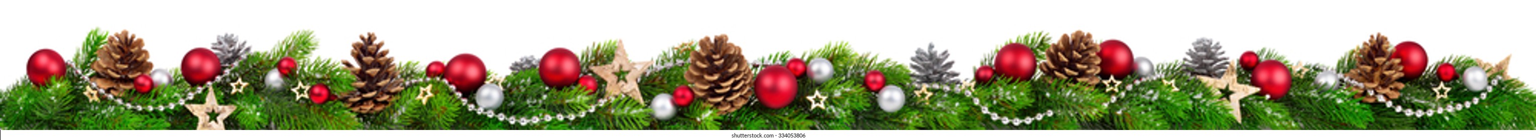 Extra wide Christmas border with fir branches, red and silver baubles, pine cones and other ornaments, isolated on white