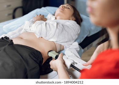 Extracorporeal shockwave therapy in urology. Cropped shot of lying woman patient, having ultrasound to determine kidney stones position before the lithotripsy procedure. - Shutterstock ID 1894004212