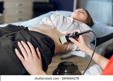 Extracorporeal shockwave therapy in urology. Cropped shot of lying woman patient, having ultrasound to determine kidney stones position before the lithotripsy procedure. - Shutterstock ID 1894004278